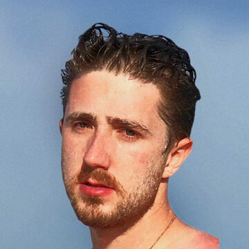 sun beach candid portrait of human gen x cousin. a cape cod 9 out of 10 and model gaze in the moment. okay: it's really sunscreen got in his eyes. afternoon sun glow lighting creates a baroque looking composition. it was edited with affinity photo.